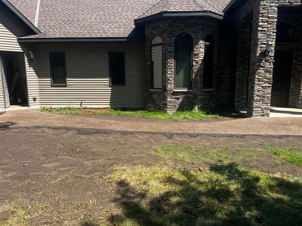 Exposed aggregate walkway along the front of a stone-accented home